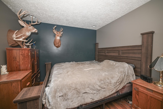 bedroom featuring a textured ceiling and wood finished floors