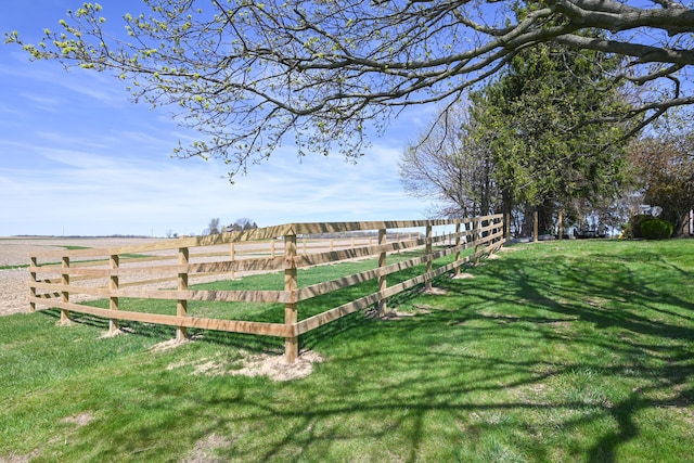 view of yard with fence and a rural view