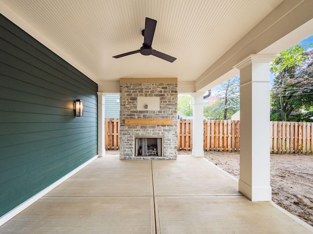 view of patio / terrace with an outdoor brick fireplace, fence, and ceiling fan