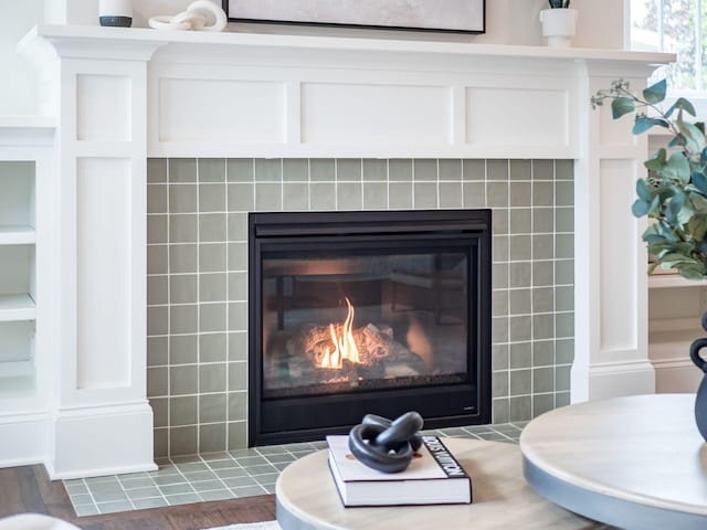 detailed view of a tile fireplace and wood finished floors