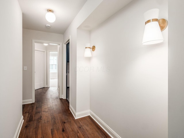 corridor featuring dark wood-style floors and baseboards