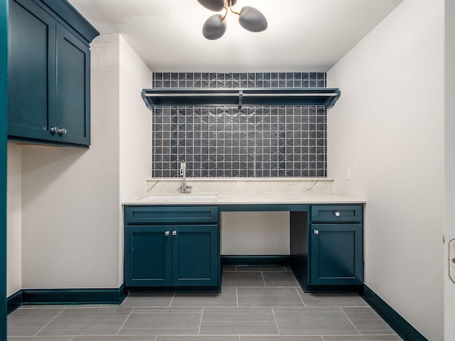 laundry room with a sink and baseboards
