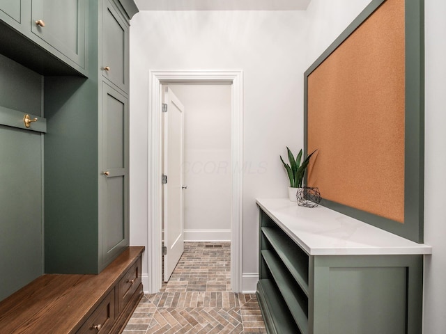 mudroom with baseboards and brick patterned flooring