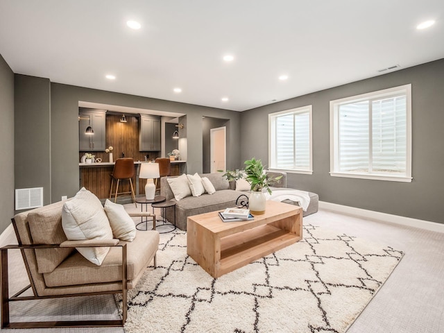 living area featuring baseboards, recessed lighting, and light colored carpet