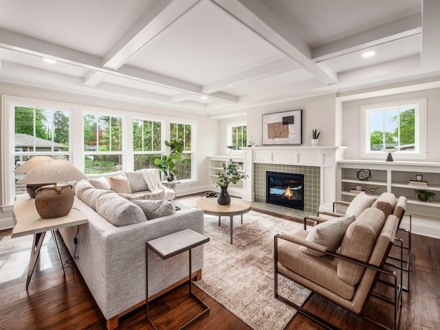 living area featuring coffered ceiling, wood finished floors, a fireplace, plenty of natural light, and beam ceiling