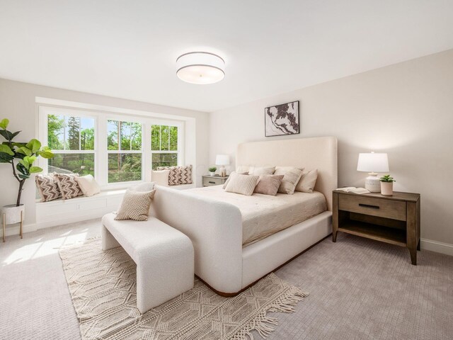 bedroom featuring light colored carpet and baseboards