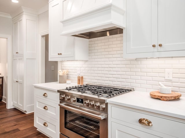 kitchen featuring gas range, premium range hood, white cabinets, light countertops, and recessed lighting