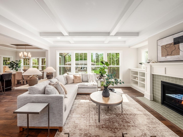 living room with a fireplace, healthy amount of natural light, beamed ceiling, dark wood-style flooring, and a chandelier