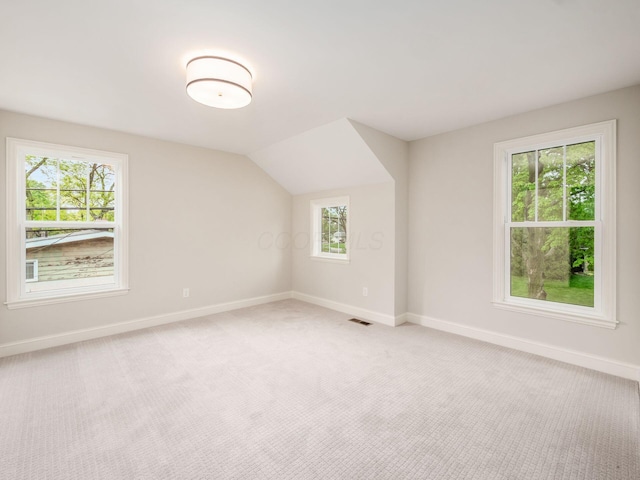 bonus room featuring baseboards, light carpet, and vaulted ceiling