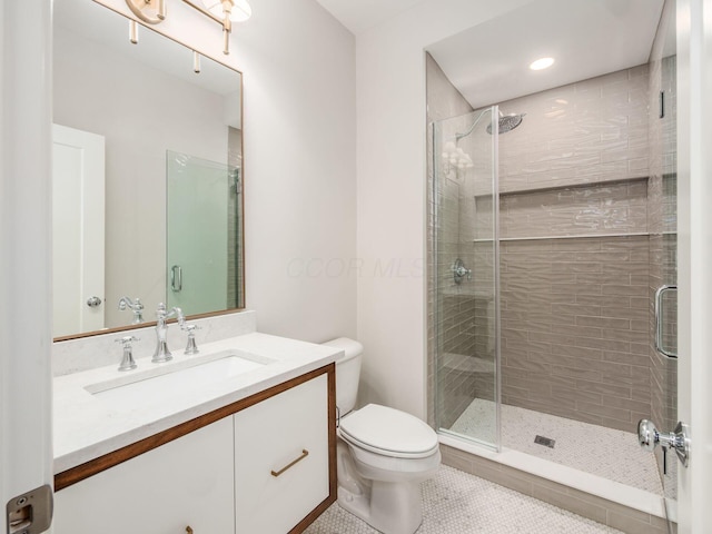 full bath featuring a stall shower, tile patterned flooring, toilet, and vanity