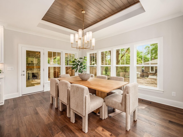dining area featuring a raised ceiling, baseboards, a chandelier, dark wood-type flooring, and ornamental molding