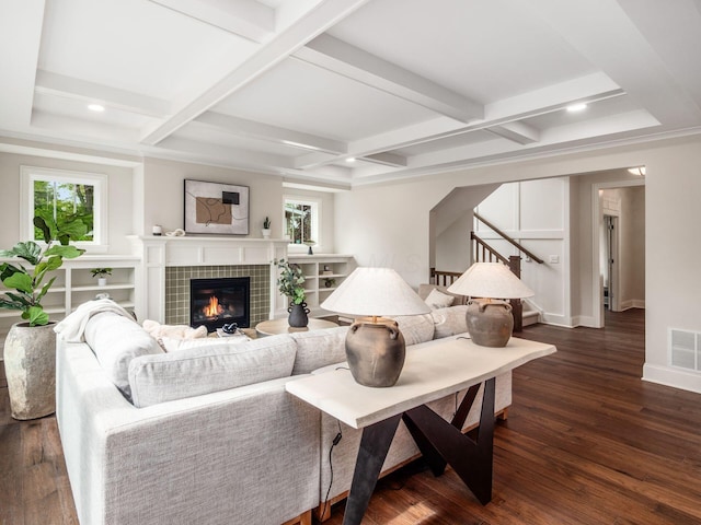 living area featuring coffered ceiling, stairway, a fireplace, dark wood finished floors, and beamed ceiling
