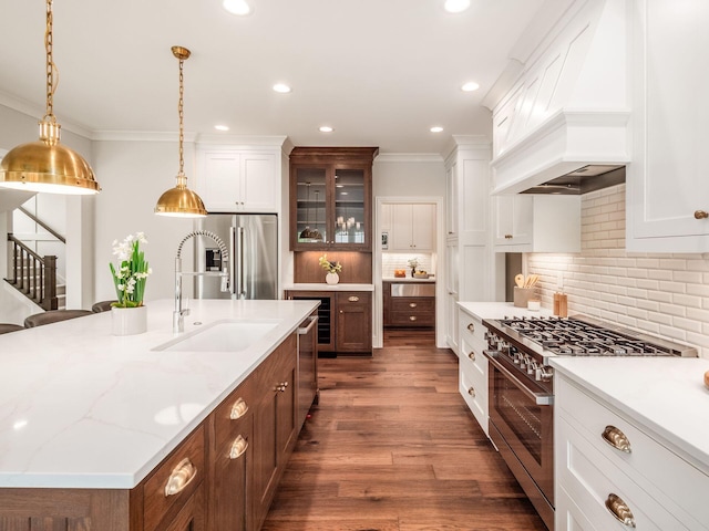 kitchen with high quality appliances, a sink, crown molding, glass insert cabinets, and white cabinets