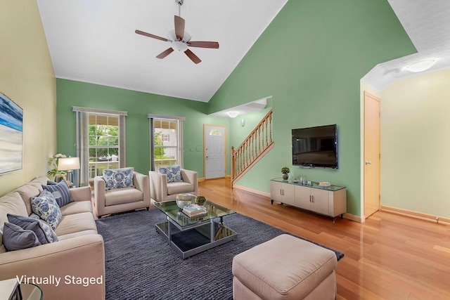 2977 Highwall Way, Columbus, OH 43221 - living room featuring a ceiling fan, stairway, wood finished floors, high vaulted ceiling, and baseboards