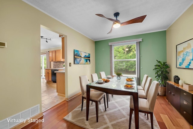 2977 Highwall Way, Columbus, OH 43221 - dining room with plenty of natural light, a ceiling fan, light wood-type flooring, crown molding, and a textured ceiling