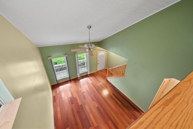2977 Highwall Way, Columbus, OH 43221 - unfurnished living room featuring a ceiling fan, baseboards, lofted ceiling, wood finished floors, and a textured ceiling
