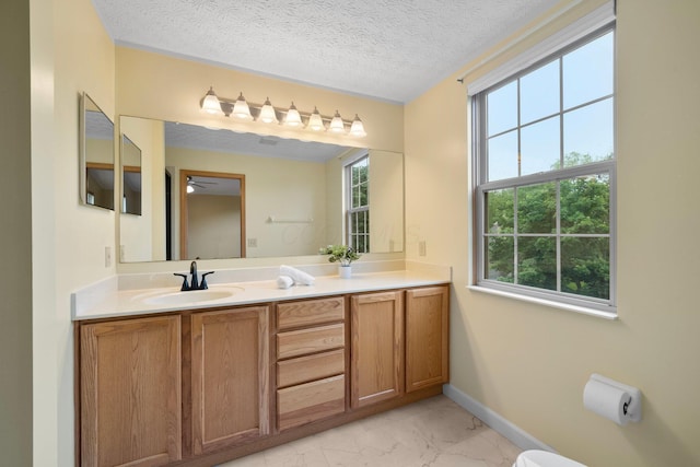 2977 Highwall Way, Columbus, OH 43221 - bathroom with marble look tiles, vanity, baseboards, a textured ceiling, and a ceiling fan