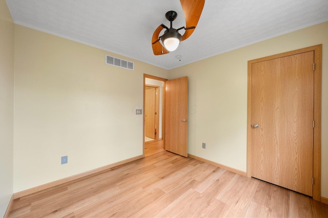 2977 Highwall Way, Columbus, OH 43221 - unfurnished bedroom featuring light wood finished floors, baseboards, a ceiling fan, and a textured ceiling
