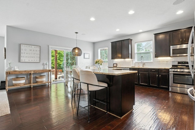 298 Long Branch Run, Delaware, OH 43015 - kitchen with stainless steel appliances, a breakfast bar area, plenty of natural light, a center island, and recessed lighting