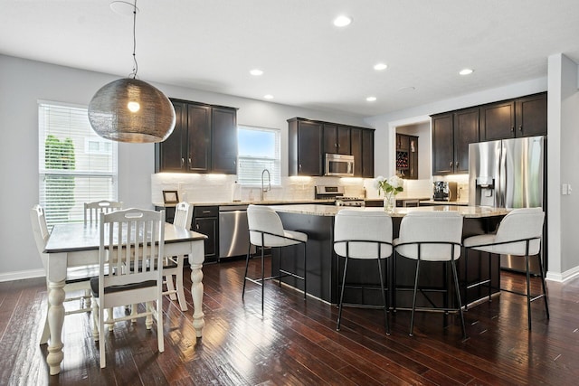 298 Long Branch Run, Delaware, OH 43015 - kitchen with appliances with stainless steel finishes, a center island, backsplash, dark brown cabinets, and dark wood-type flooring