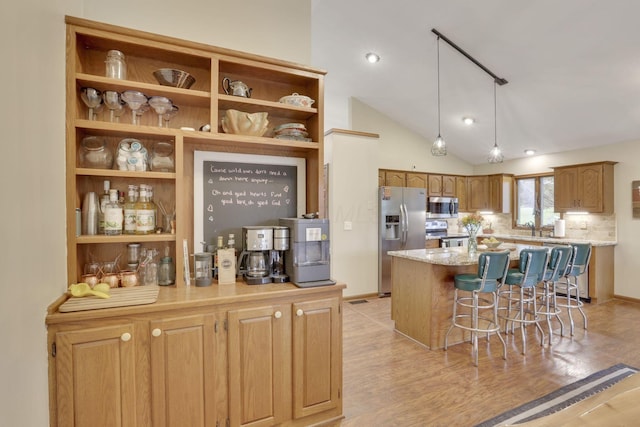 1909 Carroll Eastern Rd NW, Lancaster, OH 43130 - kitchen with decorative backsplash, a kitchen island, light stone counters, a breakfast bar, and stainless steel appliances