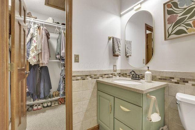 1909 Carroll Eastern Rd NW, Lancaster, OH 43130 - bathroom featuring toilet, tile walls, wainscoting, and vanity