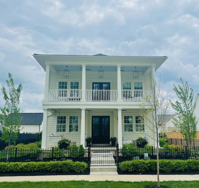 view of front of home with a porch, french doors, a fenced front yard, a gate, and a balcony
