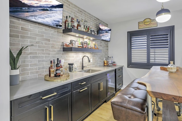 5519 Evans Farm Dr, Lewis Center, OH 43035 - bar with indoor wet bar, a sink, pendant lighting, light wood-type flooring, and backsplash