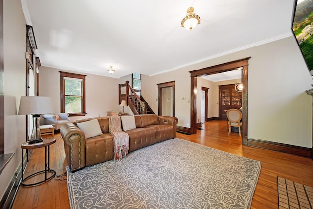 living area with stairway, baseboards, ornamental molding, and wood finished floors