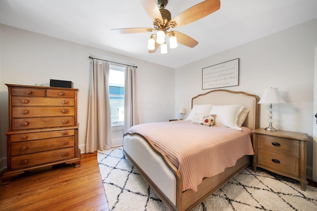 bedroom featuring light wood-type flooring, a ceiling fan, and baseboards