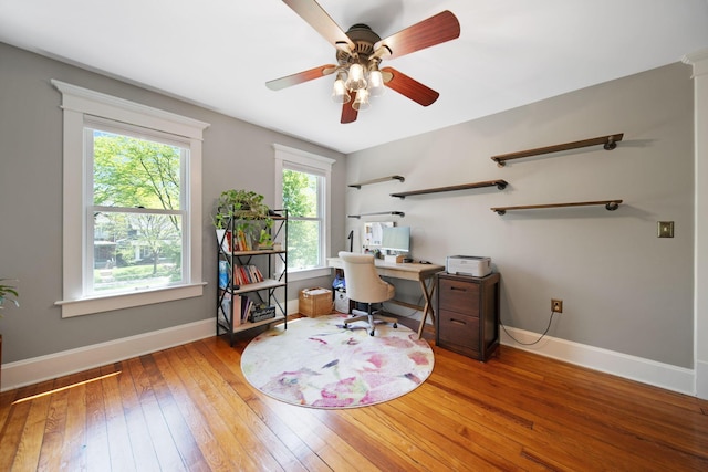 office area featuring a ceiling fan, baseboards, and hardwood / wood-style flooring