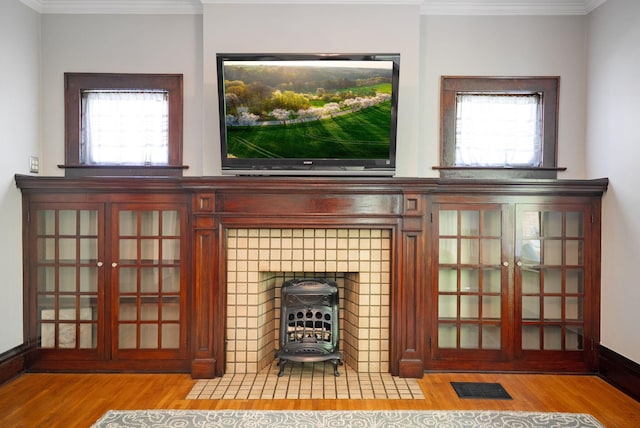 interior details featuring visible vents, ornamental molding, and wood finished floors