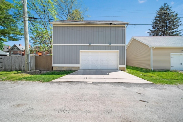 detached garage with fence and driveway