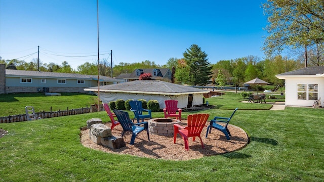 view of yard with a fire pit and fence