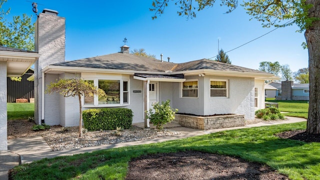 view of front of house featuring a front lawn, stucco siding, and a chimney