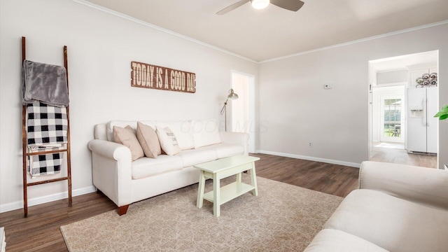 living room with baseboards, ornamental molding, a ceiling fan, and wood finished floors