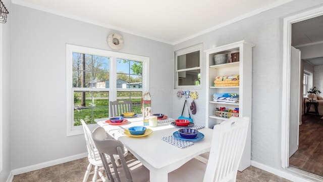 dining space featuring crown molding and baseboards