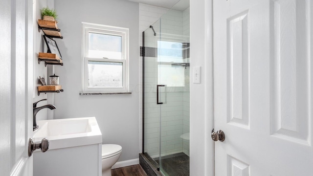 full bath with toilet, baseboards, a sink, and a stall shower