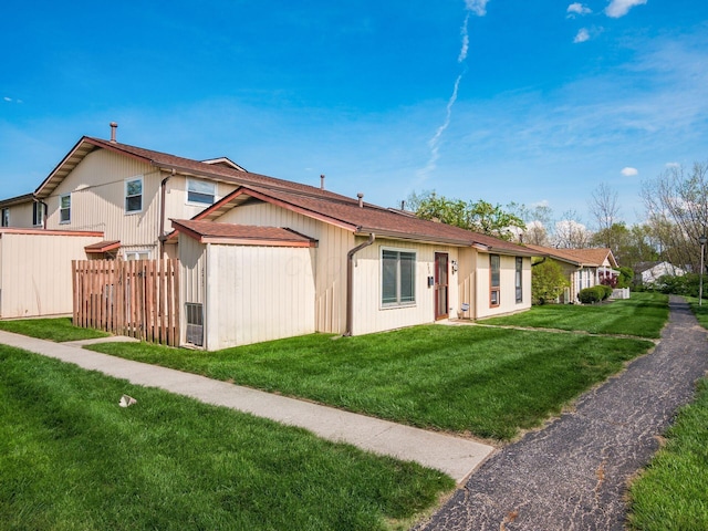 view of front of house with a front lawn and fence