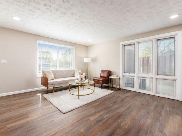 living room featuring a textured ceiling, wood finished floors, recessed lighting, and baseboards