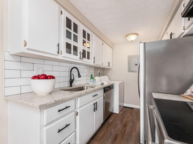 kitchen featuring appliances with stainless steel finishes, backsplash, dark wood-style flooring, a sink, and white cabinetry