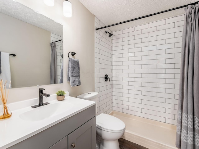 full bath with a shower stall, vanity, toilet, a textured ceiling, and wood finished floors