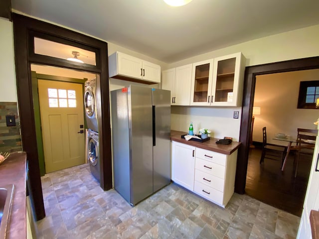 110 N Ogden Ave, Columbus, OH 43204 - kitchen with stacked washer / drying machine, glass insert cabinets, wooden counters, white cabinets, and freestanding refrigerator