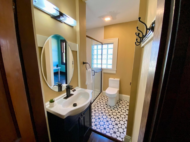 110 N Ogden Ave, Columbus, OH 43204 - full bath featuring tile patterned floors, toilet, vanity, baseboards, and a stall shower