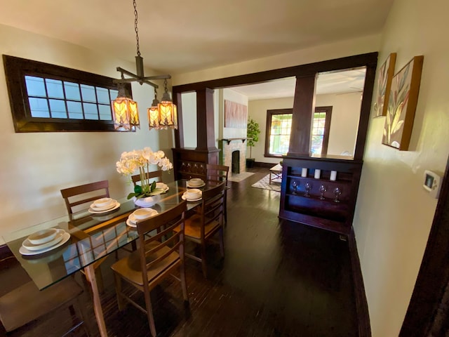 110 N Ogden Ave, Columbus, OH 43204 - dining area featuring a notable chandelier, decorative columns, wood finished floors, and baseboards