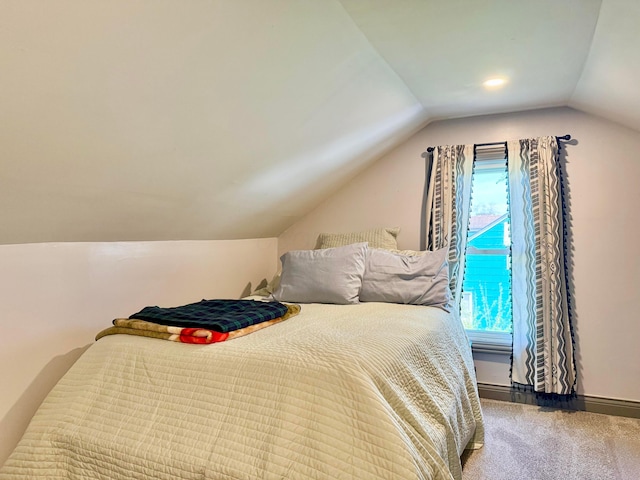 carpeted bedroom featuring vaulted ceiling and baseboards