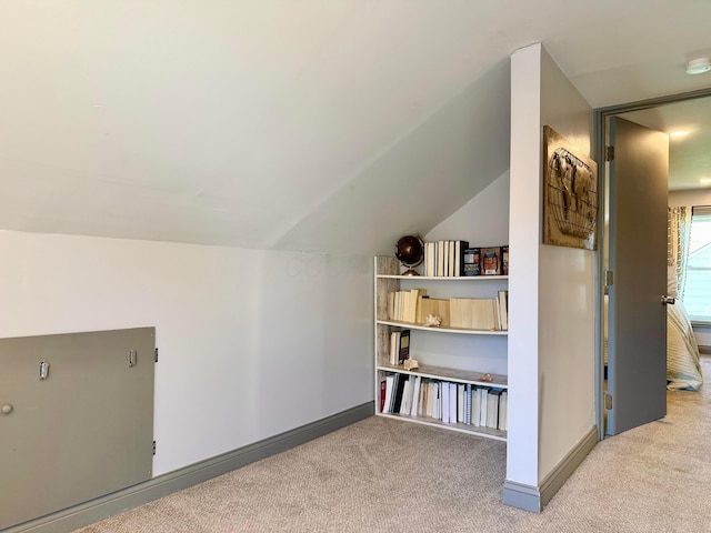 additional living space with baseboards, lofted ceiling, and carpet flooring