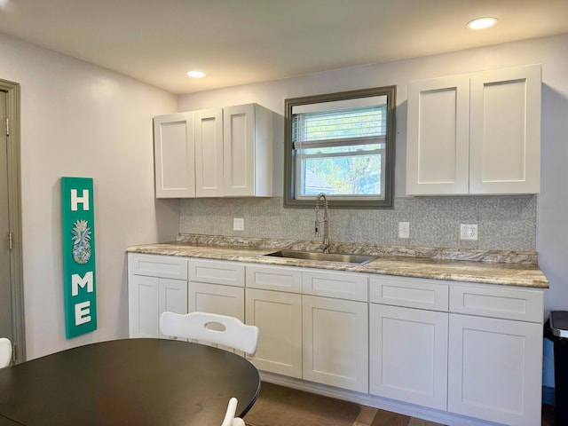 kitchen featuring recessed lighting, a sink, backsplash, and light countertops