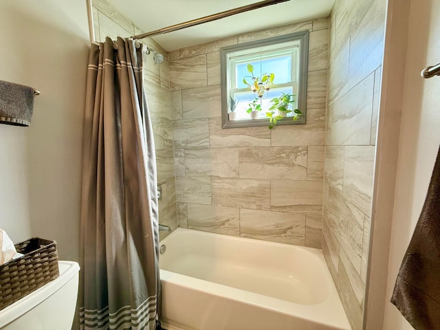 bathroom featuring shower / tub combo and toilet