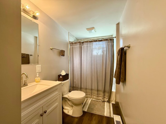bathroom with curtained shower, wood finished floors, toilet, and vanity